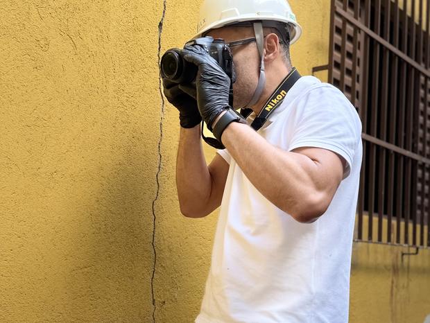 Engenheiro fotografando elemento construtivo durante vistoria